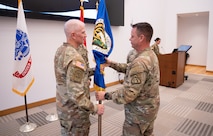 Col. Anthony Gibbs, left, receives the organizational charter from Brig. Gen. Christopher Schneider, Program Executive Officer (PEO) Soldier, assuming responsibility of Project Manager Soldier Warrior, during a change of charter ceremony held on Fort Belvoir, May 25. Project Manager Soldier Warrior rapidly delivers and sustains innovative solutions for Soldiers that enable maneuver and lethal effects on enemy forces. (U.S. Army Photo by Jason Amadi, PEO Soldier Public Affairs)