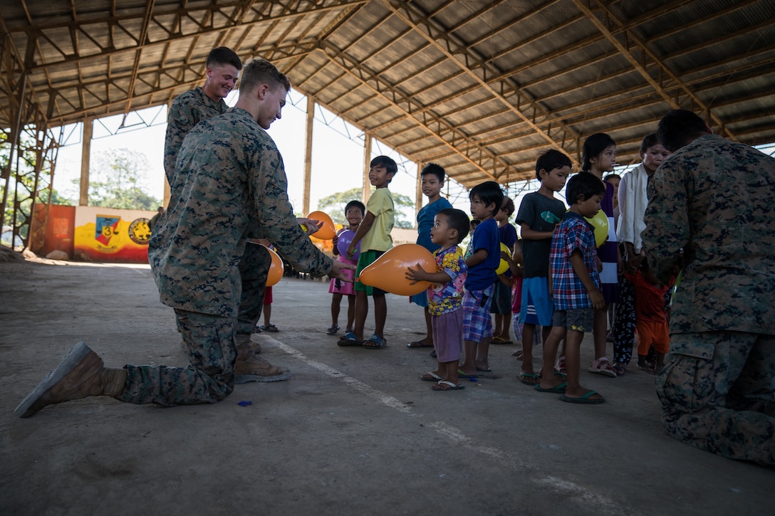 U.S. Marine Lance Cpl. Tristan Steckl hands a young boy a balloon during a community relations event in support of Exercise Balikatan at Calangitan Elementary School in Capas, Tarlac, Philippines, April 23, 2018. Steckl is a combat engineer with Alpha Company, 9th Engineer Support Battalion, and is a 20-year-old native of Waukesha, Washington. Balikatan 34-2018, in its 34th iteration, is an annual U.S.-Philippine military training exercise focused on a variety of missions, including humanitarian assistance and disaster relief, counterterrorism and other combined military operations held from May 7 to 18.