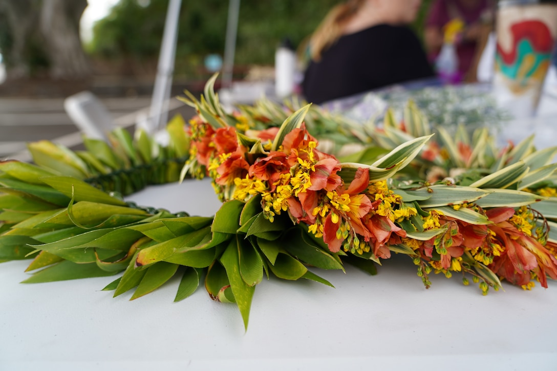 Lei Haku (left) and Lei Wili (right) sit side-by-side on a table during a lei making workshop.