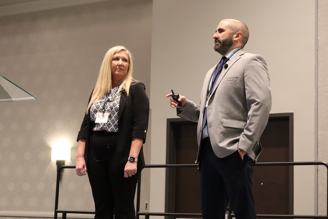 man and woman in business attire on a stage