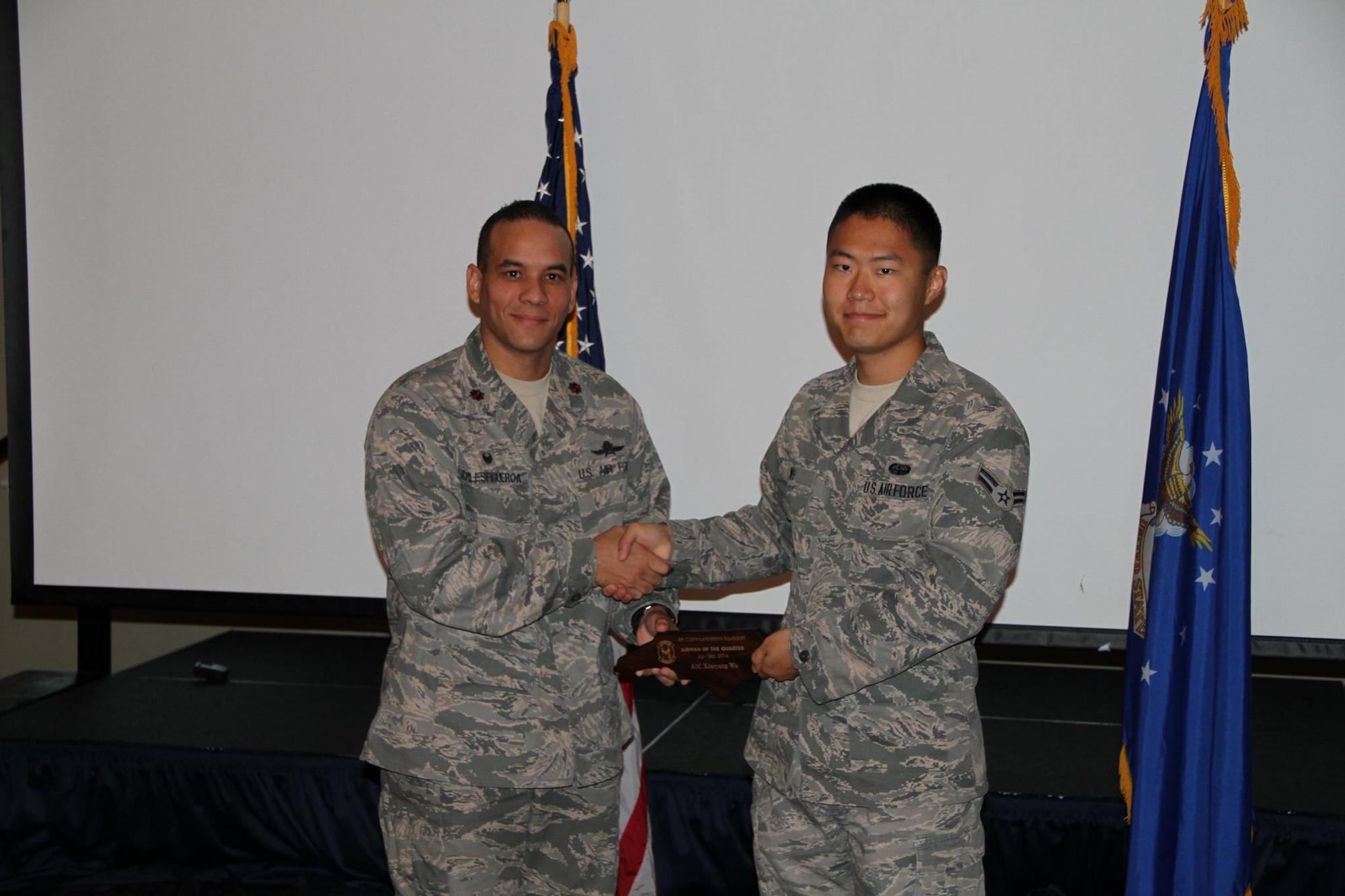 Maj. Nelson “AV” Avilesfigueroa, 4th Communications Squadron commander, presents Airman 1st Class Xiaoyang Wu, 4th CS assistant administrator, with an Airman of the Quarter award Oct. 23, 2014, at Seymour Johnson Air Force Base, North Carolina. AV inspired Wu to earn a computer science degree and go to Air Force Reserve Officer Training Corps (AFROTC). Now 1st Lt. Xiaoyang Wu, is a Joint Mission Operations Center watch officer for the 367th Cyberspace Operations Squadron, at JBSA-Lackland, Texas.