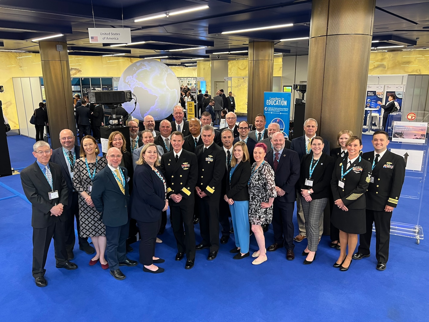 U.S. Delegation, lead by Rear Admiral Ron Piret, poses for a photo at the U.S. Booth during the International Hydrographic Organization Assembly 2023.