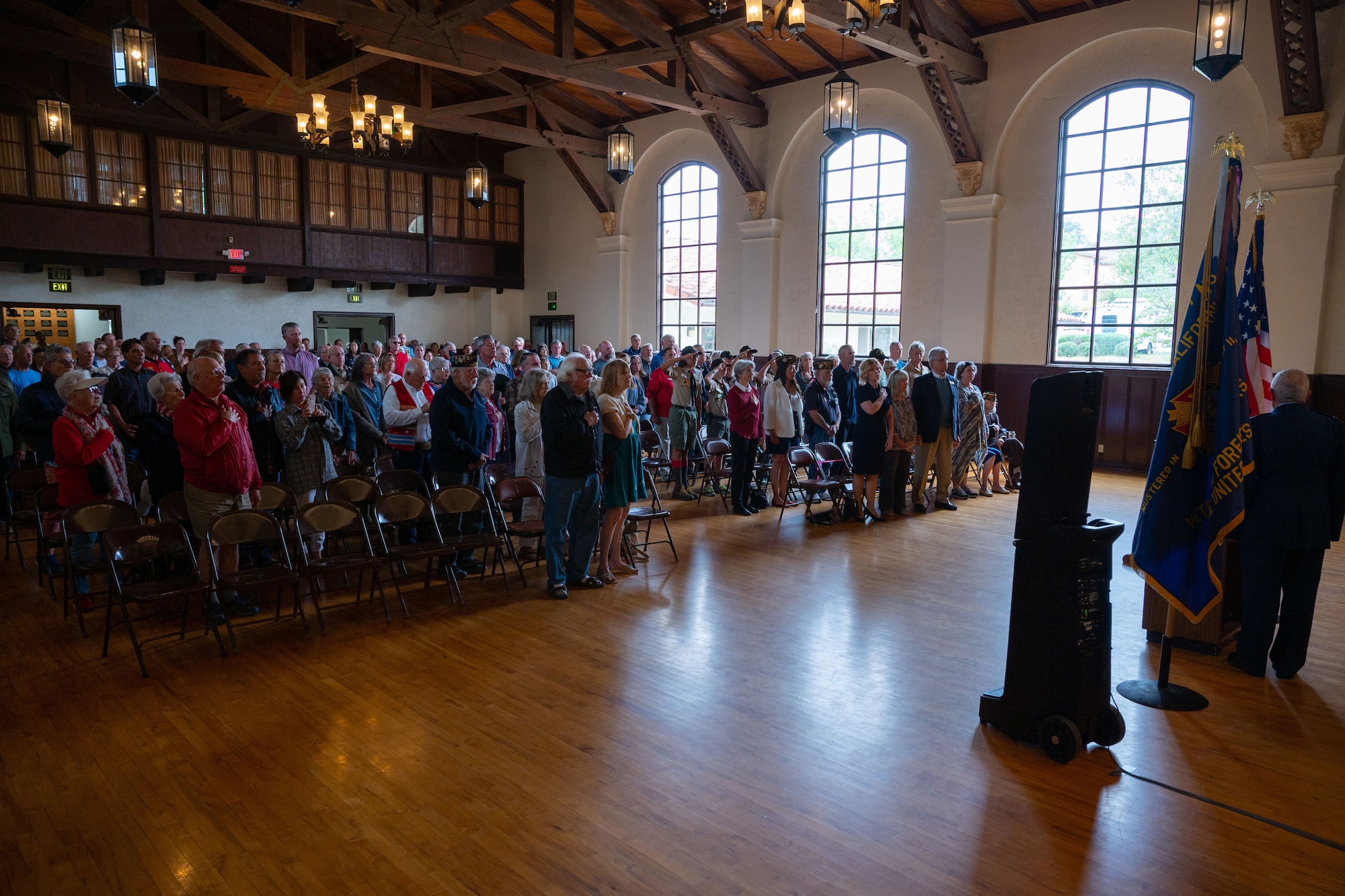 Attendees participate in the Pledge of Allegiance during a Memorial Day ceremony at the Solvang Veterans Memorial Hall in Solvang, Calif., May 29, 2023. U.S. Space Force Maj. Gen. Douglas A. Schiess, Combined Force Space Component Command commander, delivers his keynote speech to over 200 attendees during a Memorial Day ceremony at the Solvang Veterans Memorial Hall in Solvang, Calif., May 29, 2023. The attendees included veterans from the Global War on Terrorism, Vietnam, Korea and even one veteran from WWII. The ceremony also included the raising on the American Flag by a local Cub Scouts group and a laying of a wreath with a Gold Star family member. (U.S. Space Force photo by Tech. Sgt. Luke Kitterman)