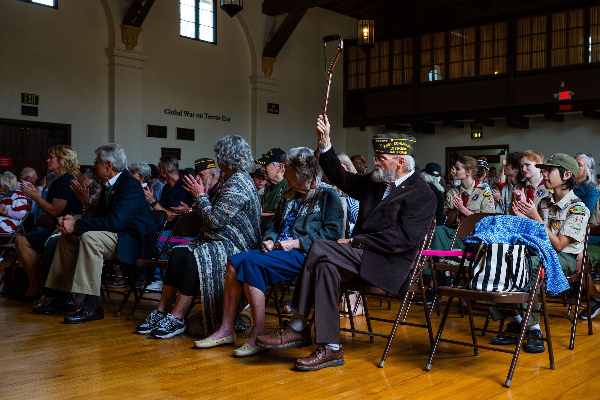 A Veteran raises his cane in recognition of being a WWII veteran during a Memorial Day ceremony at the Solvang Veterans Memorial Hall in Solvang, Calif., May 29, 2023. U.S. Space Force Maj. Gen. Douglas A. Schiess, Combined Force Space Component Command commander, delivers his keynote speech to over 200 attendees during a Memorial Day ceremony at the Solvang Veterans Memorial Hall in Solvang, Calif., May 29, 2023. The attendees included veterans from the Global War on Terrorism, Vietnam, Korea and even one veteran from WWII. The ceremony also included the raising on the American Flag by a local Cub Scouts group and a laying of a wreath with a Gold Star family member. (U.S. Space Force photo by Tech. Sgt. Luke Kitterman)