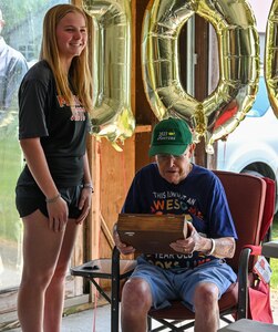 Laurence “Sparky” Rector, a World War II veteran of the Oklahoma National Guard's 45th Infantry Division, inspects an engraved box sent to him by the 45th Infantry Brigade and presented by  ROTC cadet Avery Mack on his 100th birthday in Mexico, N.Y., May 27. Rector fought through Europe with the division and went on to be a successful wrestling coach and a beloved member of his community after the war. (New York National Guard photo by Staff Sgt. Matthew Gunther)