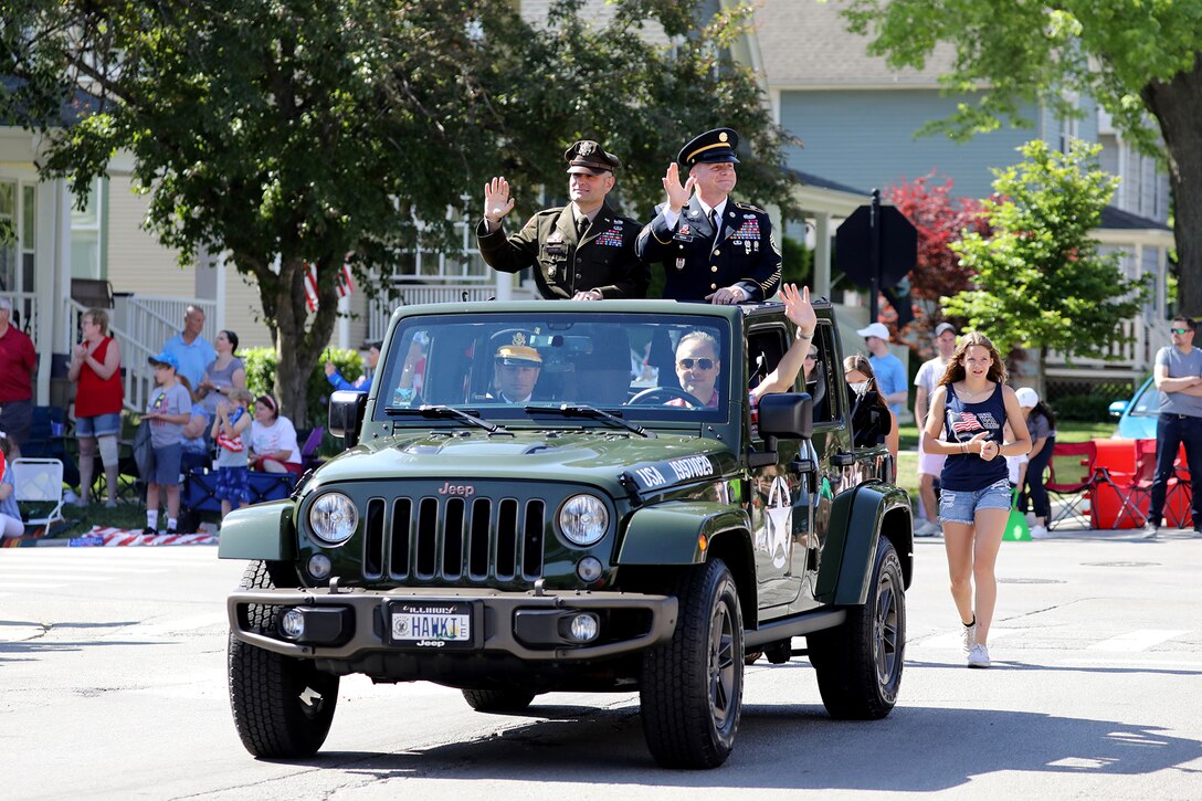 Brig. Gen Richard W. Corner, II, Commanding General, 85th U.S. Army Reserve Support Command, left, and retired Sgt. Maj. Dennis Koski ride in an Army-style jeep, during the annual Arlington Heights Memorial Day parade, May 29, 2023.