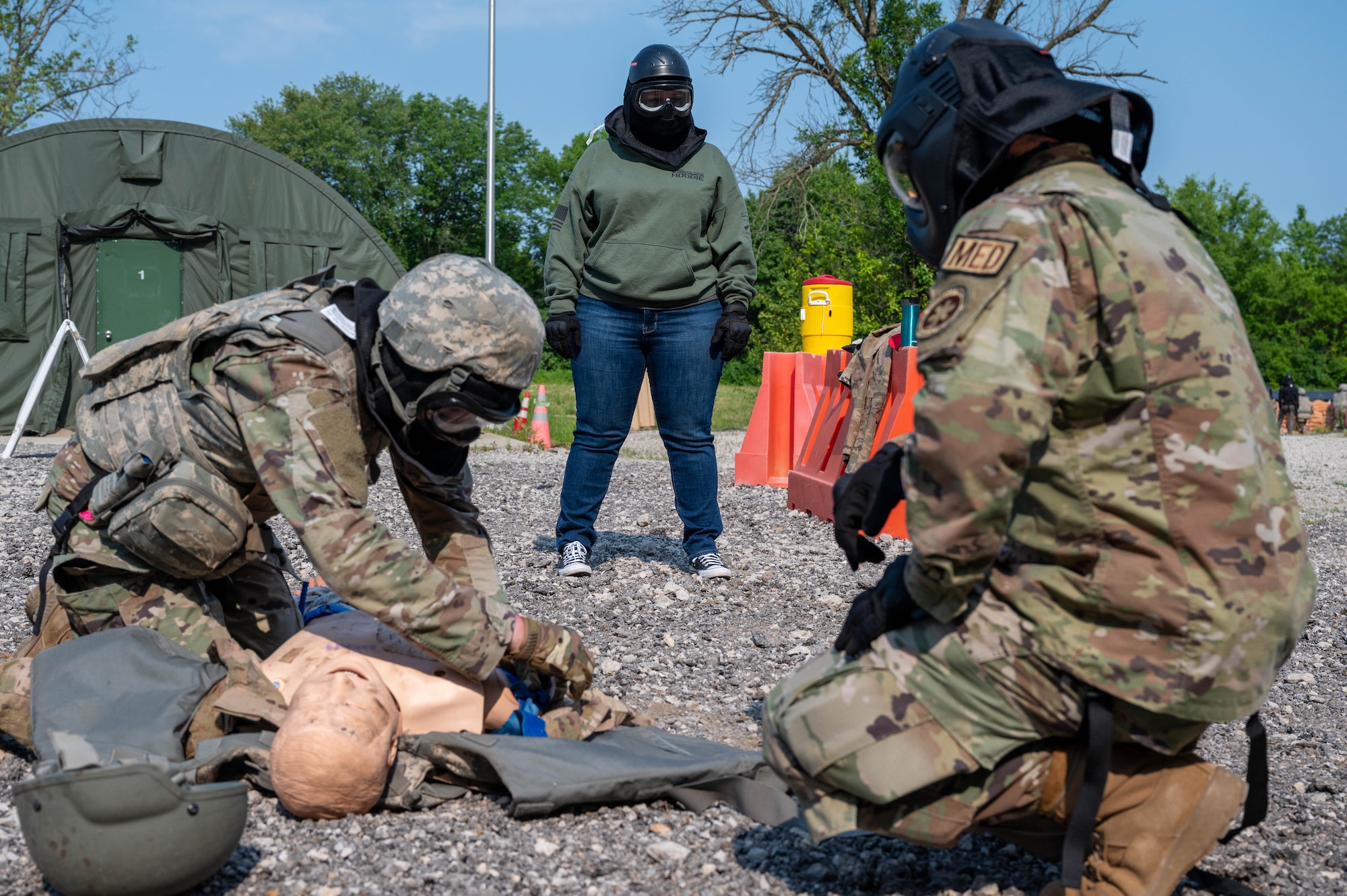 Person watches Airmen practice first-aid.