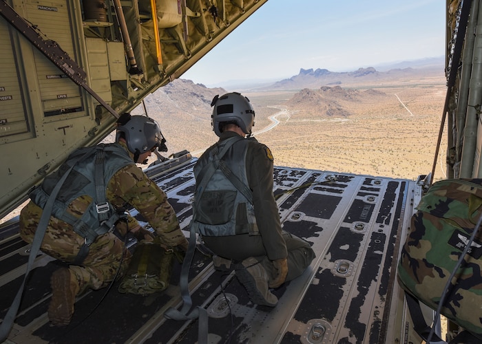 U.S. Air Force Staff Sgt. Miles Morissette, 79th Rescue Squadron aircraft loadmaster, and Senior Airman Eric Hust, 563d Operational Support Squadron aircraft loadmaster, perform parabundle drops during a Combat Search and Rescue training mission, June 6, 2019. Loadmaster directed parabundle drops are roughly 15-20 pounds of necessary materials needed to resupply pararescuemen on the ground during rescue missions. (U.S. Air Force photo by Airman 1st Class Kristine Legate)