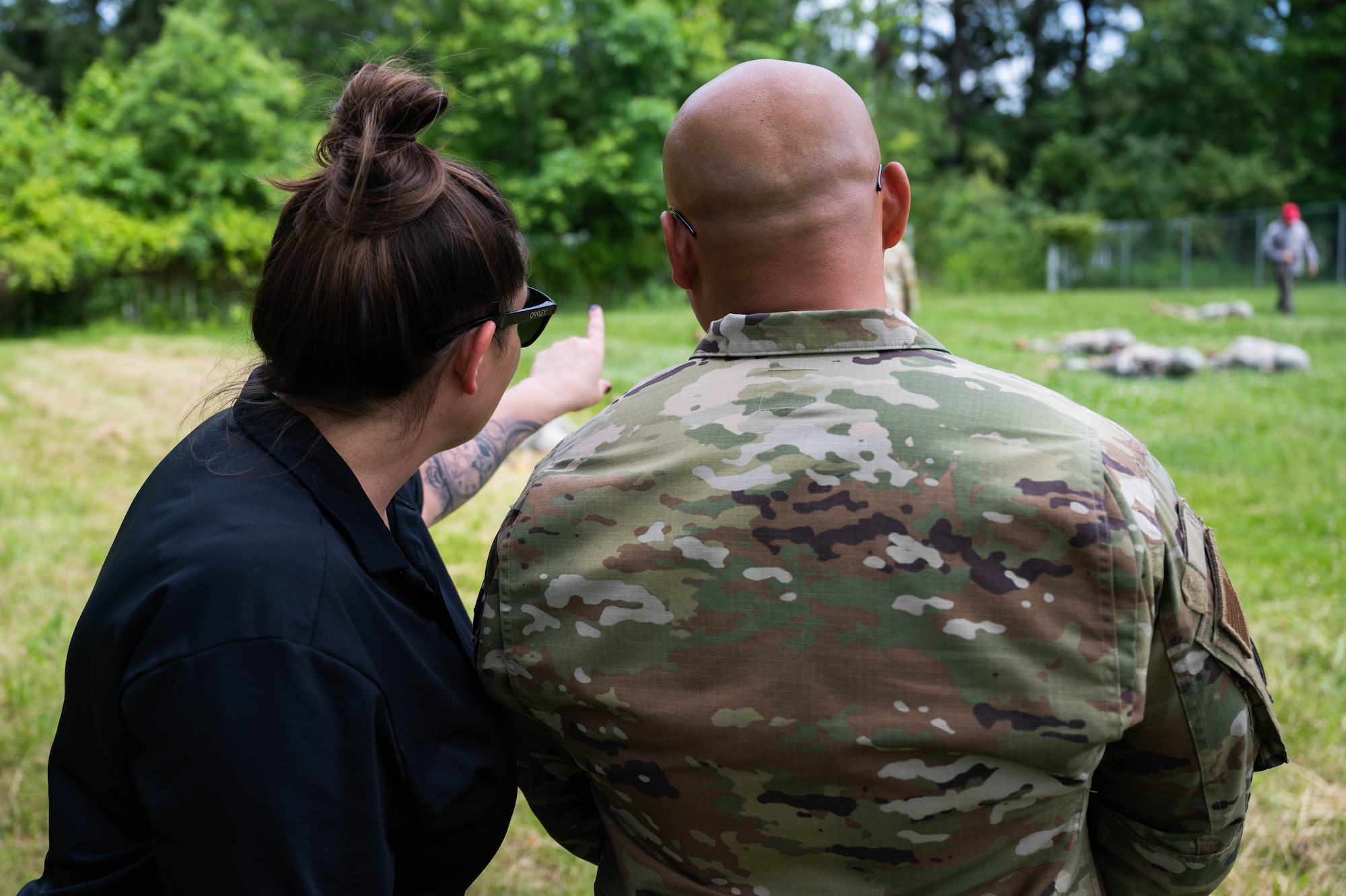 Two people watch Airmen