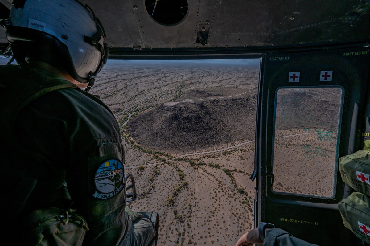 U.S. Marine Corps Lance Cpl. Arcand Andrew, Helicopter Marine Light Attack Squadron 775, 4th Marine Air Wing, helicopter crew chief, looks at surroundings over Arizona, May 14, 2023. Andrew took part in an escort mission exercise in a U.S. Marine Corps UH-1Y Venom helicopter. (U.S. Air Force photo by Airman 1st Class Jhade Herrera)