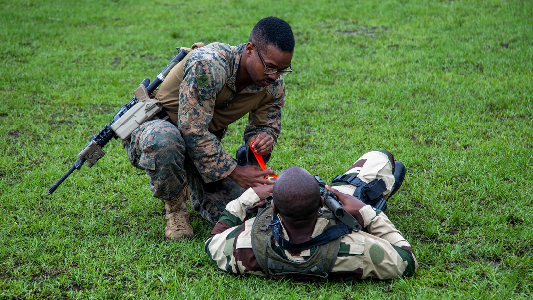 U.S. Marine Corps Lance Cpl. John McFarland, a Gulfport, MS native and rifleman with Task Force 61/2.3 Fleet Anti-terrorism Security Team Europe, applies a training tourniquet to a Gabonese Republican soldier while rehearsing tactical combat casualty care, during Judicious Activation 2023 in Libreville, Gabon, Apr. 27, 2023. Task Force 61/2.3 provides capabilities such as rapid response expeditionary anti-terrorism and security operations in support of Commanders, United States European Command  and as directed by Commander, U.S. 6th Fleet in order to protect vital naval and national assets.