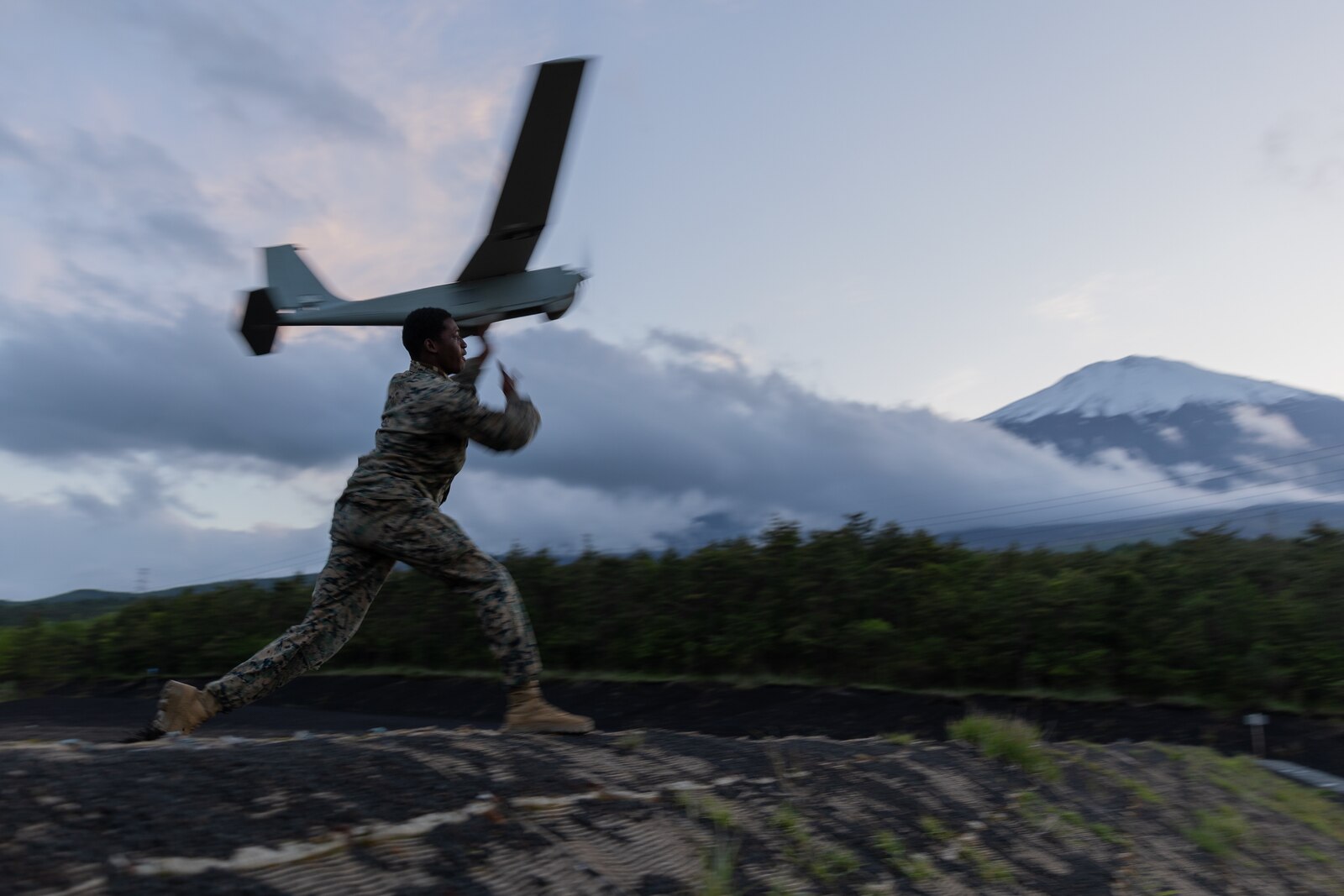 U.S. Marine Corps Lance Cpl. Zamar Roberts launches an RQ-20B Puma at Combined Arms Training Center Camp Fuji, Japan, May 24, 2023. The RQ-20B provides enhanced sensing capabilities to Marines on the ground, increasing battlespace awareness and relaying vital information to commanders. Roberts, an Antigua and Barbuda native, is a rifleman with 3d Battalion, 6th Marines and is currently forward-deployed in the Indo-Pacific under 4th Marines, 3d Marine Division as part of the Unit Deployment Program. (U.S. Marine Corps photo by Cpl. Noah Masog)