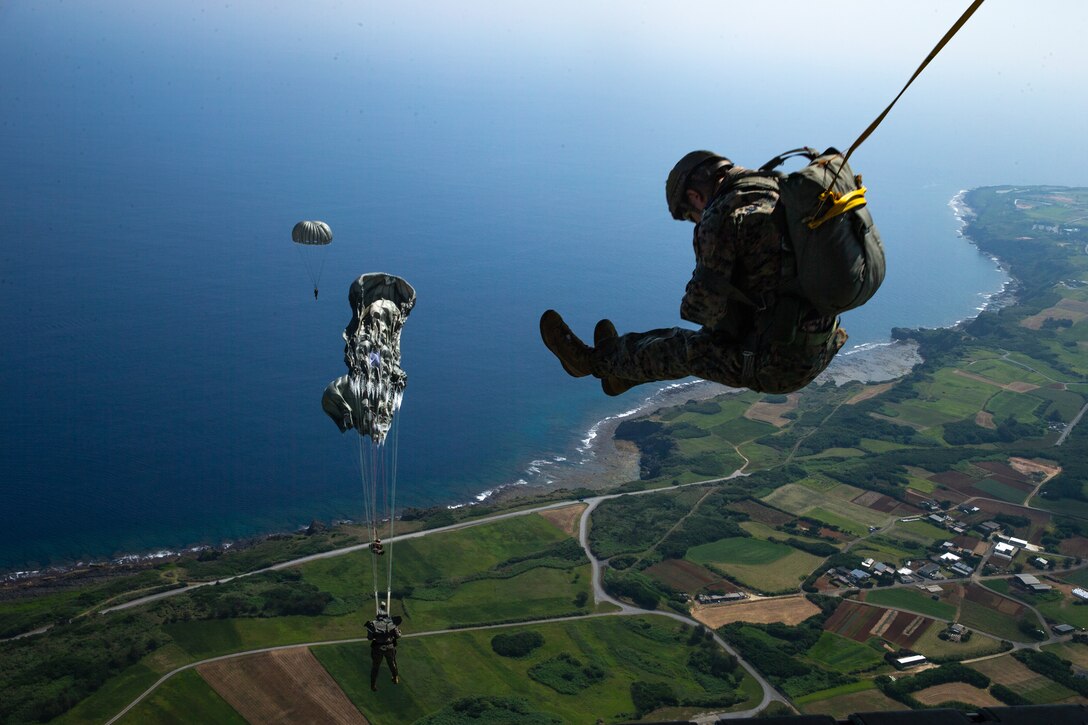 U.S. Marines with 3d Reconnaissance Battalion jump from a KC-130J Super Hercules assigned to Marine Aerial Refueler Transport Squadron 152, Marine Aircraft Wing 36 during Military Free Fall and Low-Level Static Line parachute operations over Ie Shima, Okinawa, Japan, May 16, 2023. The training sustains operational readiness while ensuring Marines are prepared to rapidly insert into austere environments through multiple methods. (U.S. Marine Corps photo by Cpl. Michael Taggart)
