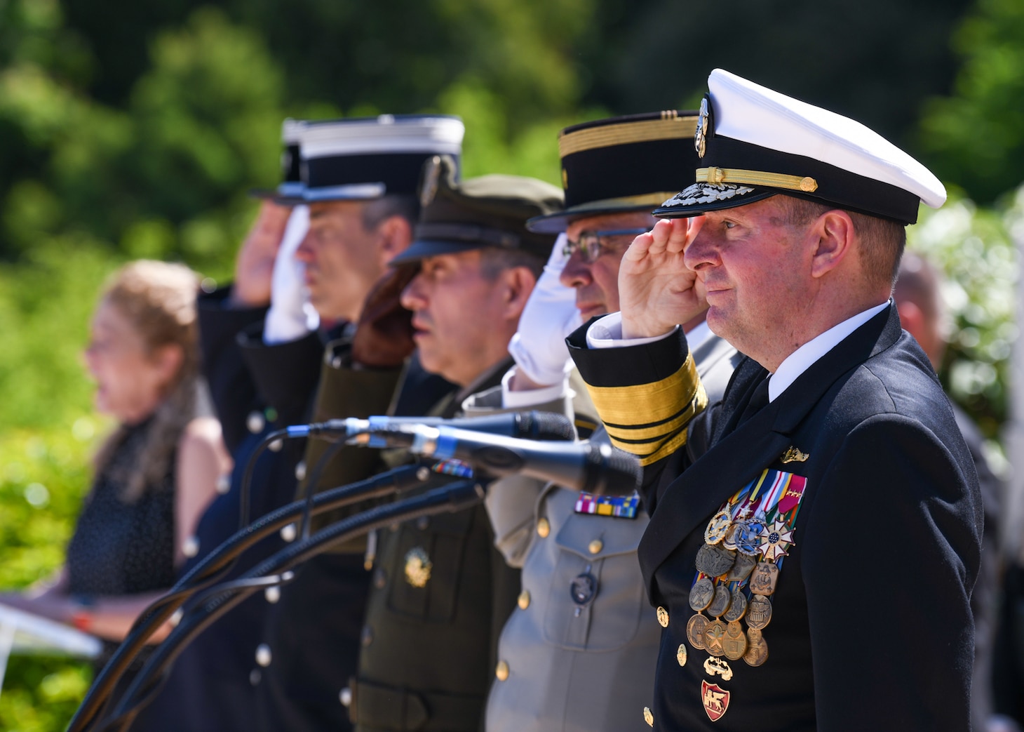 ROMAGNE-SOUS-MONTFAUCON, France (May 28, 2023) - U.S. Navy Adm. Stuart B. Munsch, commander for the U.S. Naval Forces Europe – Africa and Allied Joint Force Command Naples, along with other Admirals throughout the regions render salute during the national anthems (La Marseillaise & Star-Spangled Banner) sung by Mrs. Amy Malone at the Meuse-Argonne American Cemetery ceremony in Romagne-sous-Montfaucon, France, May 28, 2023. Admirals from the U.S. Naval Forces Europe-Africa, U.S. Sixth Fleet, and Navy Region Europe, Africa, Central traveled throughout Europe visiting American Battle Monuments Commission cemeteries to honor the lives and legacies of fallen U.S. and Allied service members who paid the ultimate price through servicing their countries. Headquarters in Naples, Italy, NAVEUR-NAVAF operates U.S. naval forces in the U.S. European Command and U.S. Africa Command area of responsibility. U.S. Sixth Fleet is permanently assigned to NAVEUR-NAVAF and employs maritime forces through the full spectrum of joint and naval operations.