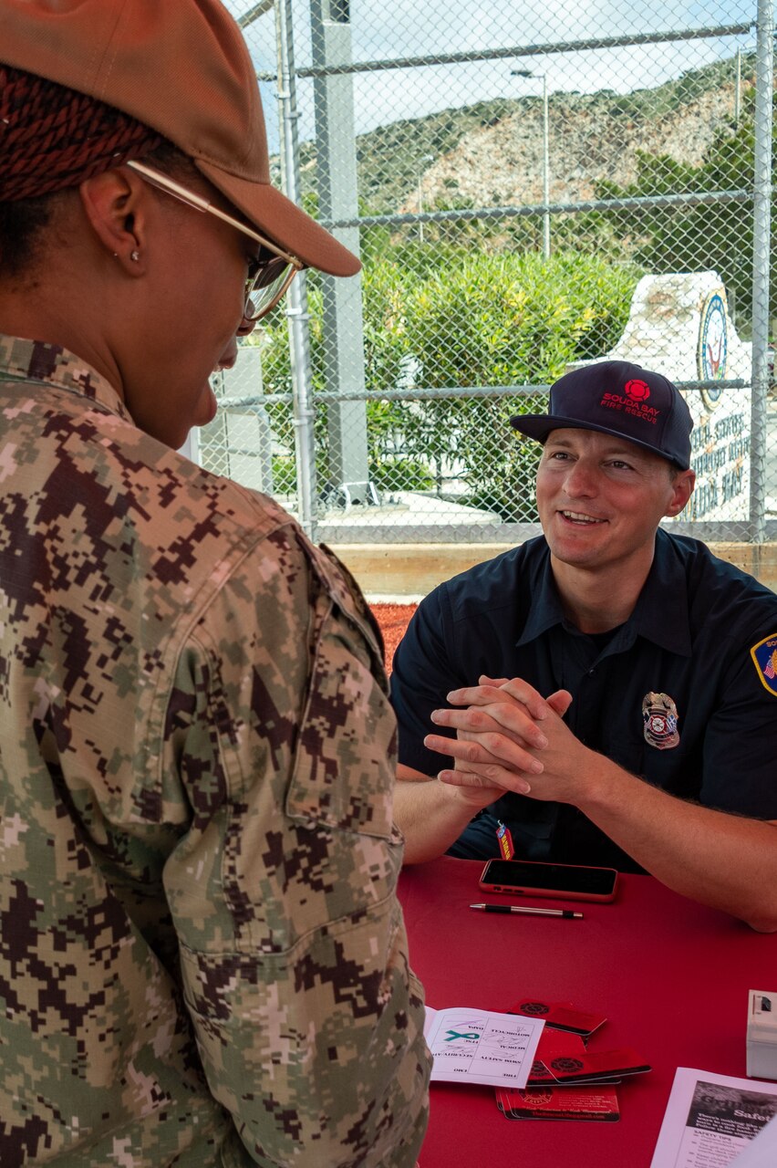 Fireman Matthew Labrise, Naval Support Activity (NSA) Souda Bay, talks about the importance of knowing the proper CPR techniques during a Summer Safety Stand Down event hosted by the NSA Souda Bay Safety Office at the base softball field on May 12, 2023. Sailors and civilian employees participated in the safety stand down by attending multiple resource stations to learn how to stay safe while participating in summertime activities.