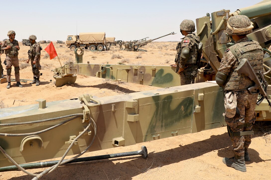 Members of Tunisian armed forces watch as Soldiers with C Battery, 1-107th Field Artillery Regiment, 2nd Infantry Brigade Combat Team, 28th Infantry Division prepare their M777 Howitzer to fire May 27, 2023 at Ben Ghilouf Training Area, Tunisia. African Lion 23 demonstrates the United States’ long-term commitment to improve partner nation capacity and capabilities in support of U.S. strategic objectives. Eighteen nations and approximately 8,000 personnel will participate in African Lion 23, U.S. Africa Command's largest annual combined, joint exercise that will take place in multiple countries to include Tunisia from May 13 - June 18, 2023. (U.S. Army photo by 1st Sgt. HollyAnn Nicom)