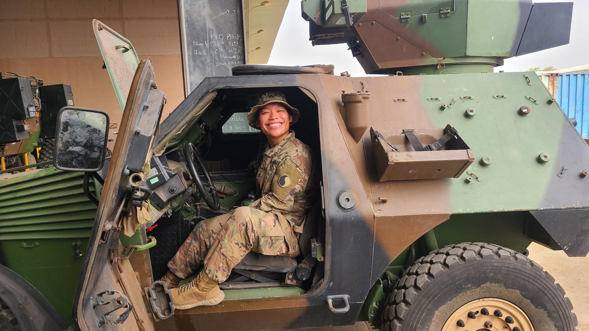 A female Soldier poses inside a vehicle.