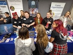 Ella Walker, middle left, component repair technician, Shop 31, Inside Machinist, talks with a group of students about future career opportunities at Puget Sound Naval Shipyard & Intermediate Maintenance Facility May 5, 2023, during a Washington Women in Trades Fair at the Seattle Center Pavilion. (U.S Navy photo by Wendy Hallmark)
