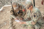 Sgt. Jackson McNair, C Battery, 1st Battalion, 107th Field Artillery Regiment, 2nd Infantry Brigade Combat Team, 28th Infantry Division, Pennsylvania National Guard, reviews notes with a member of the Tunisian armed forces in Ben Ghilouf, Tunisia, during African Lion 23, May 25, 2023. Eighteen nations and approximately 8,000 personnel are participating in U.S. Africa Command's largest annual combined, joint exercise in multiple countries May 13-June 18, 2023. (Blurred for OPSEC purposes.)