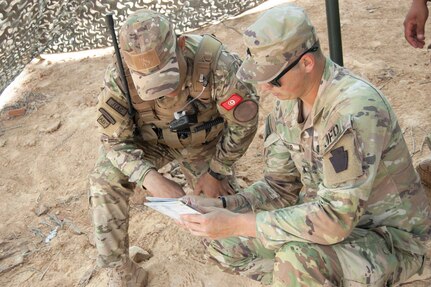 Sgt. Jackson McNair, C Battery, 1st Battalion, 107th Field Artillery Regiment, 2nd Infantry Brigade Combat Team, 28th Infantry Division, Pennsylvania National Guard, reviews notes with a member of the Tunisian armed forces in Ben Ghilouf, Tunisia, during African Lion 23, May 25, 2023. Eighteen nations and approximately 8,000 personnel are participating in U.S. Africa Command's largest annual combined, joint exercise in multiple countries May 13-June 18, 2023. (Blurred for OPSEC purposes.)