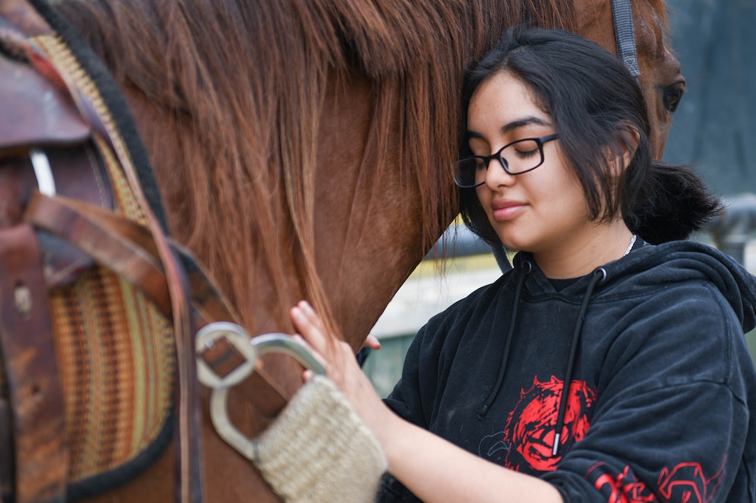 A sailor pets a horse.