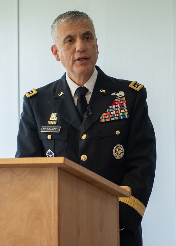 A man in a military uniform speaks from behind a podium