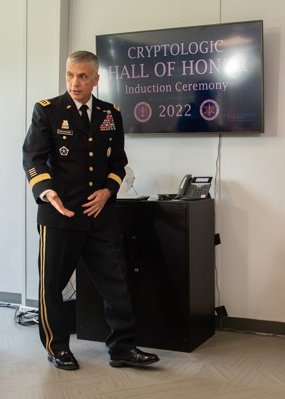 A man in a military uniform walks and talks while gesturing with his hands