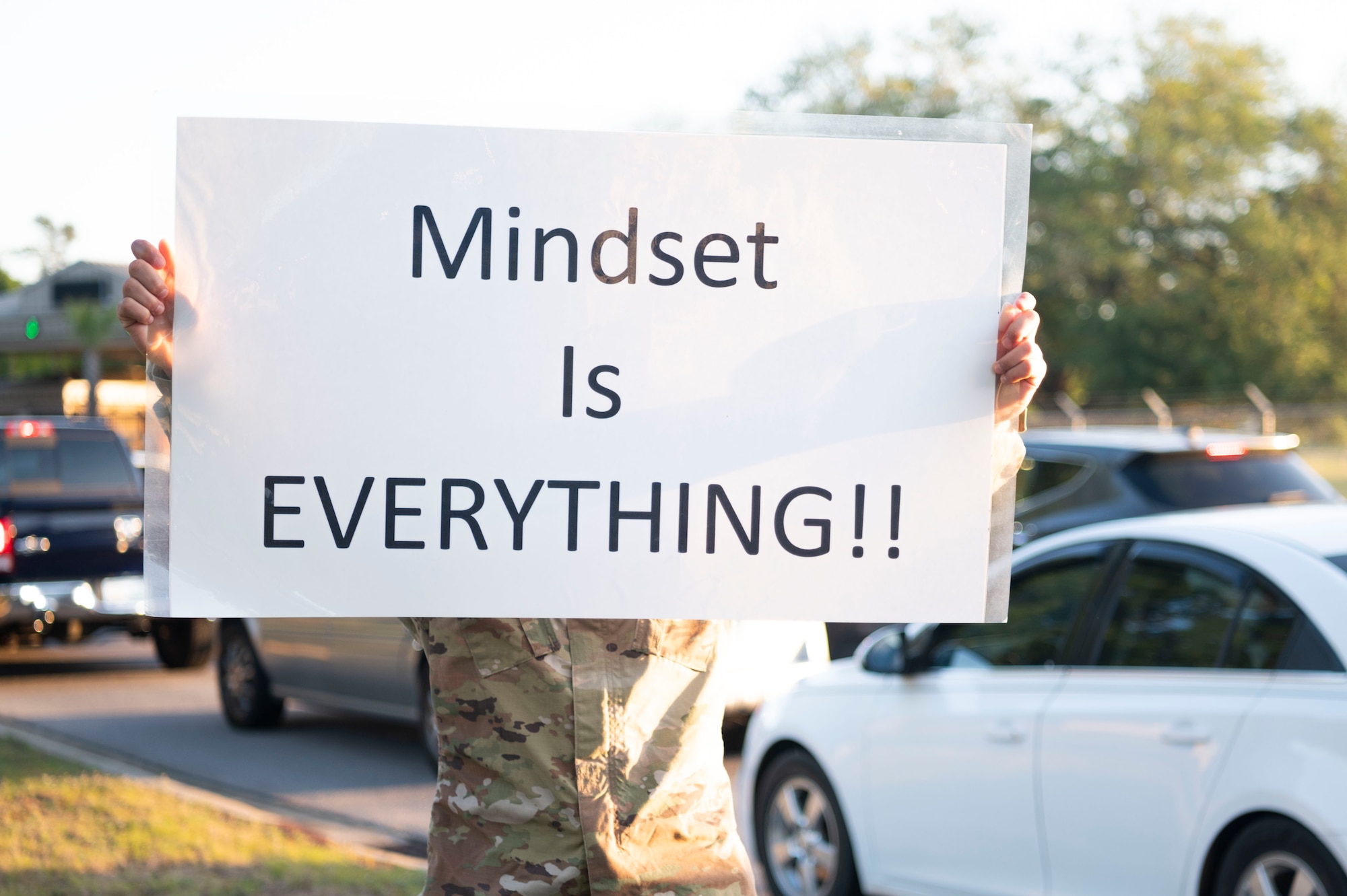 A U.S. Airman takes part in the Inspire Shaw campaign by displaying a sign at Shaw Air Force Base, S.C., May 1, 2023. The phrases found on Inspire Shaw posters are meant to boost mental wellness, promoting resiliency and growth within Shaw Airmen. (U.S. Air Force photo by Senior Airman Isaac Nicholson)