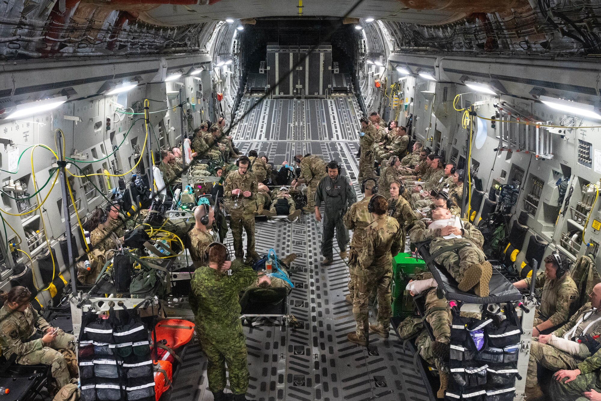 Airmen from the 934th Aeromedical Evacuation Squadron, 934th Security Forces Squadron, 934th Aeromedical Staging Squadron, 934th Civil Engineering Squadron, 452nd Aeromedical Evacuation Squadron, 452nd Aircraft Maintenance Squadron and the Royal Canadian Air Force work together to conduct a training exercise at the Minneapolis-St. Paul Air Reserve Station, May 5, 2023. The majority of the exercise took place aboard a C-17 Globemaster III aircraft but involved multiple patient transfers from UH-60 Blackhawk helicopters. (U.S. Air Force photo by Senior Airman Victoriya Tarakanova)