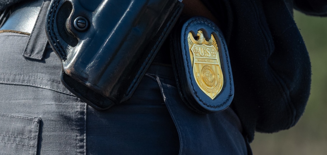 The NCIS Special Agent badge rests on the hip of a Special Agent during a training exercise.