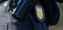 The NCIS Special Agent badge rests on the hip of a Special Agent during a training exercise.