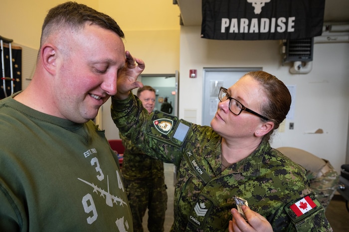 Royal Canadian Air Force Sgt. Stephanie Simpson, a 17th Field Ambulance noncommissioned member, right, applies foil to Master Sgt. Jesse Toombs, a 934th Aeromedical Evacuation Squadron medical technician, to simulate shrapnel wounds for a training exercise at  the Minneapolis-St. Paul Air Reserve Station, May 5, 2023. Simpson and other members of the Royal Canadian Air Force worked with the 934 AES previously on similar training exercises. (U.S. Air Force photo by Senior Airman Victoriya Tarakanova)