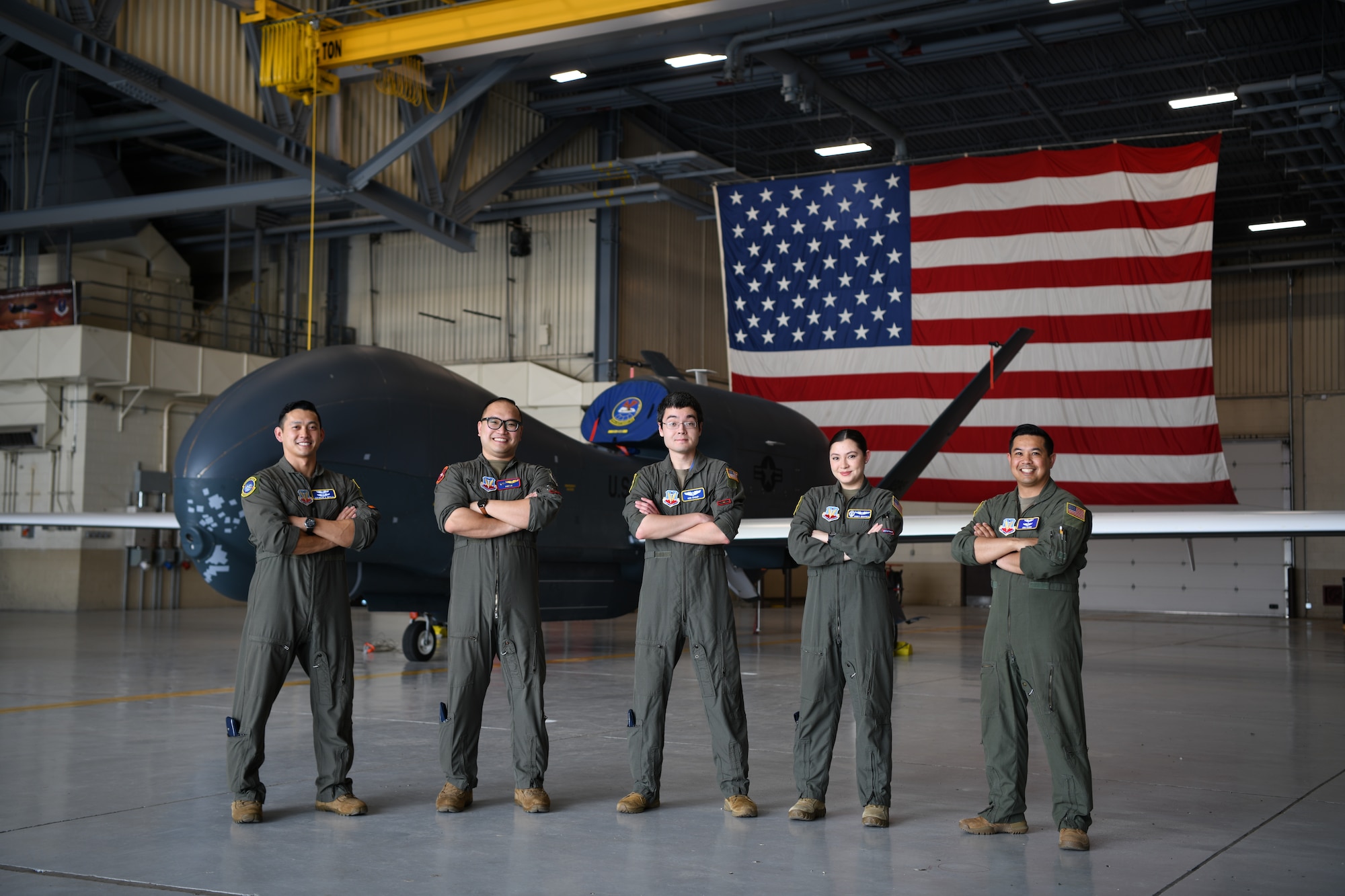 Pilots pose for photo in front of aircraft.