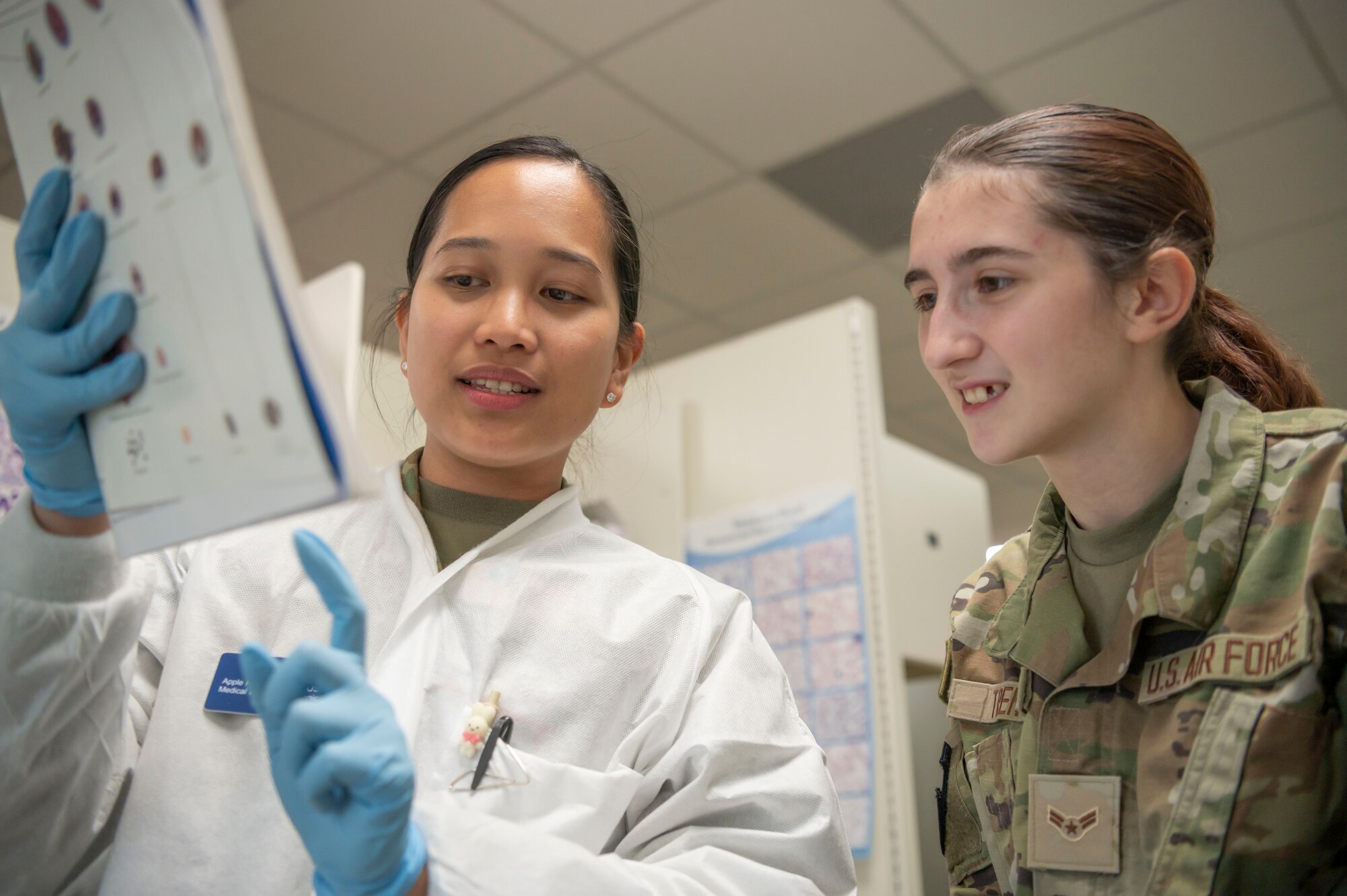 U.S. Air Force Senior Airman Apple Alterado, 20th Healthcare Operations Squadron (HCOS) medical laboratory technician, left, discusses a chart with Airman 1st Class Hannah Trent, 20th Operational Medical Readiness Squadron aerospace medical services technician, during Lab Week at Shaw Air Force Base, S.C., April 26, 2023. The 20th HCOS hosted various displays and activities during Lab Week to showcase the work that laboratory technician Airmen do to contribute to the health and readiness of the base. (U.S. Air Force photo by Senior Airman Isaac Nicholson)
