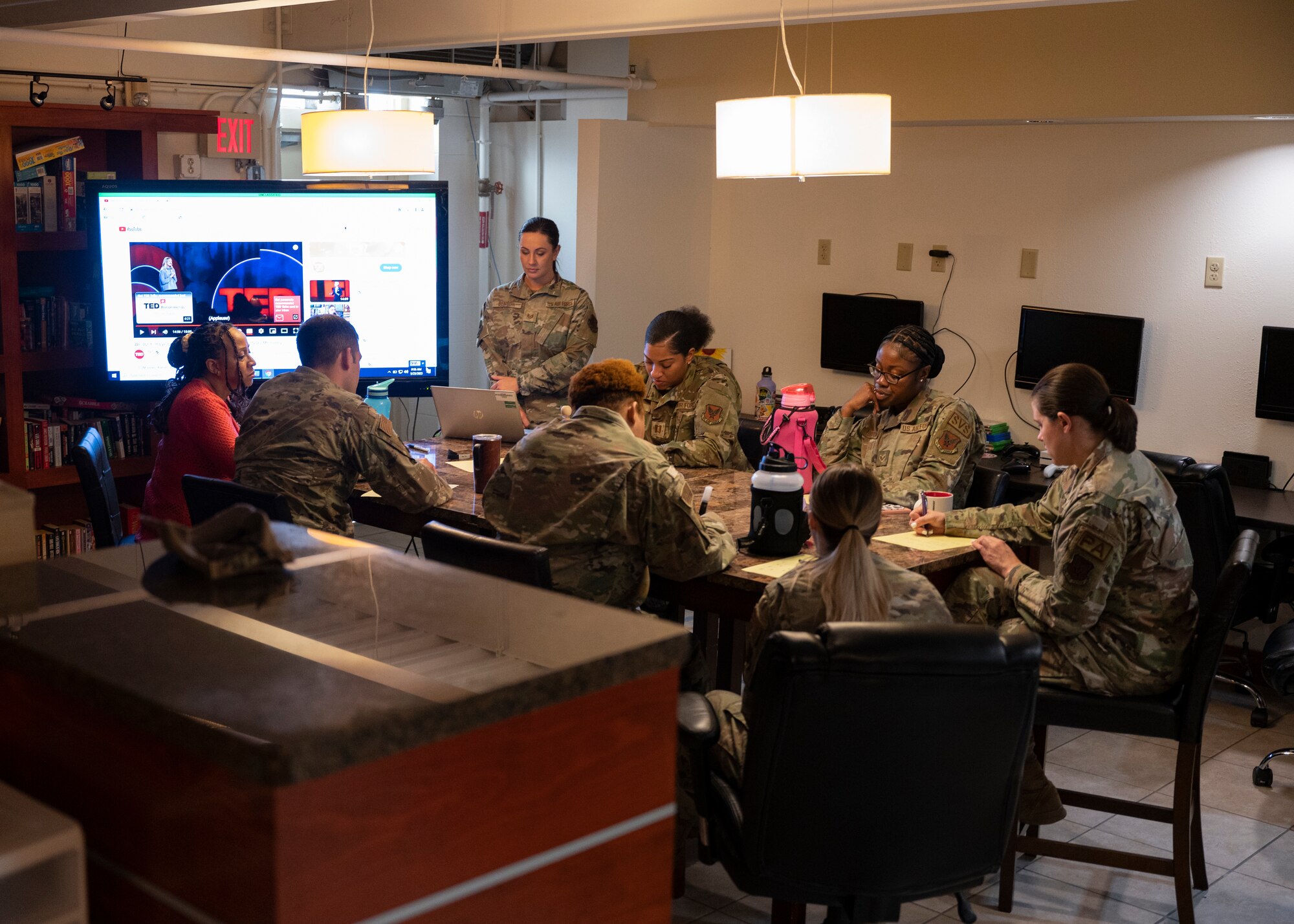 A group of Airman sit around a table.