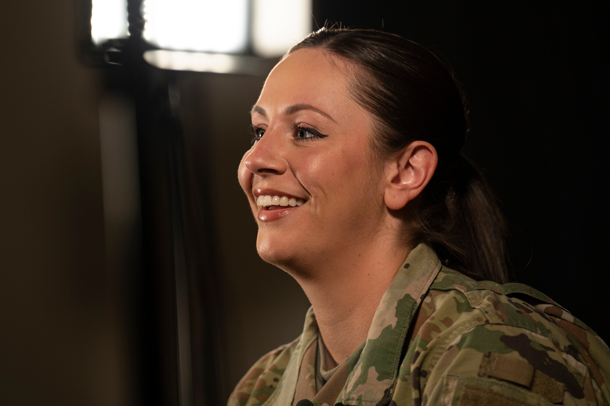 An Airman sits in a dark room.