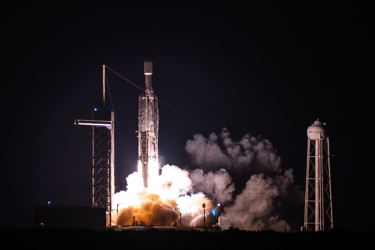 A Falcon Heavy rocket carrying three geostationary satellites launches from Launch Complex 39A at Kennedy Space Center, Florida