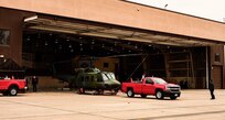 truck pulling helicopter from hangar
