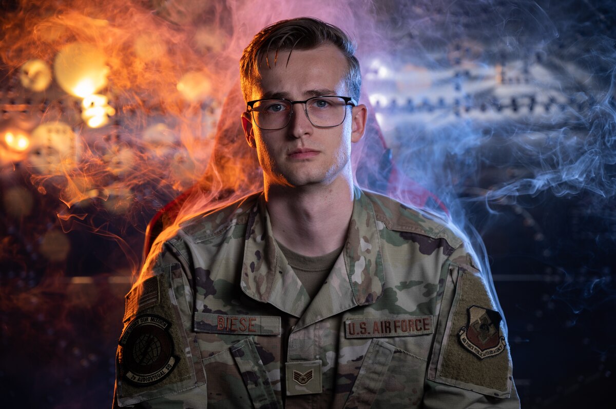 An airman in uniform with a colorful background