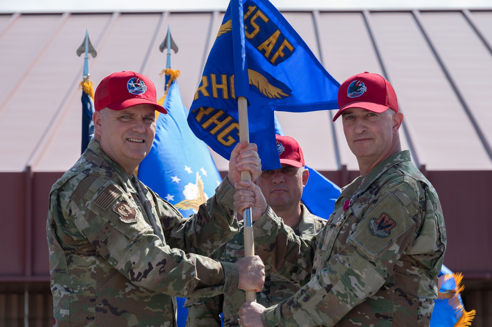 U.S. Air Force Maj. Gen. Michael Koscheski, left, 15th Air Force commander, accepts the 800th Rapid Engineering Deployable Heavy Operations Repair Squadron Engineer RED HORSE Group (RHG) guidon from Col. Matthew Welling, the outgoing RHG commander, during a change of command ceremony at Nellis Air Force Base, Nevada, May 16, 2023.