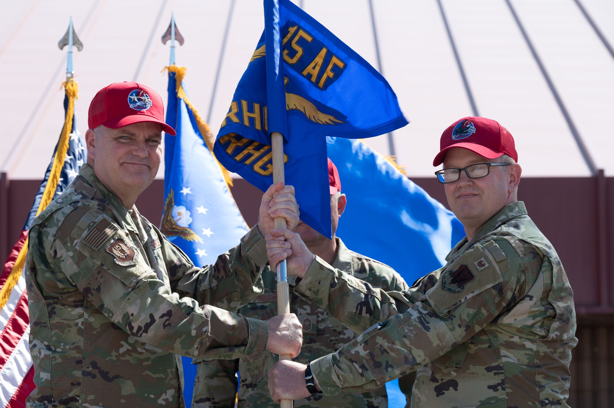 U.S. Air Force Maj. Gen. Michael Koscheski, left, 15th Air Force commander, passes the 800th Rapid Engineering Deployable Heavy Operations Repair Squadron Engineer Group (RED HORSE) Group (RHG) guidon to Col. Andrew Cullen, during a change of command ceremony on Nellis Air Force Base, Nevada, May 16, 2023.