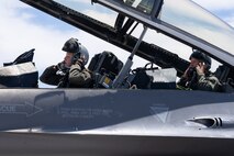 U.S. Air Force Maj. Megan Hainline, left, and Mr. Rob McHenry, the Deputy Director of the Defense Advanced Research Projects Agency (DARPA), remove their helmets after a flight at Nellis Air Force Base, Nevada, May 24, 2023.