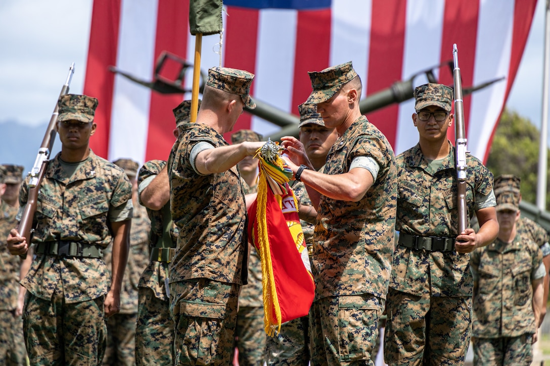 U.S. Marine Corps Lt. Col. Joseph L. Gill II, right, commanding officer, and 1st Sgt. Mark Albert, both with 1st Battalion, 12th Marines, 3d Marine Division, case the colors during the unit’s deactivation ceremony on Marine Corps Base Hawaii, May 26, 2023. The deactivation is in accordance with Force Design 2030’s modernization efforts. The battalion has played a valuable role in setting conditions for the 3d Marine Littoral Regiment, and future MLRs, to provide combat ready and lethal forces in the Indo-Pacific. 3d MLR and 12th Marines, which is scheduled to transition to an MLR in 2025, will provide ready and capable stand-in forces to the first island chain, bolstering the United States Indo-Pacific Command’s ability to support deterrence efforts and respond to potential crises with allies and partners. (U.S. Marine Corps photo by Sgt. Israel Chincio)