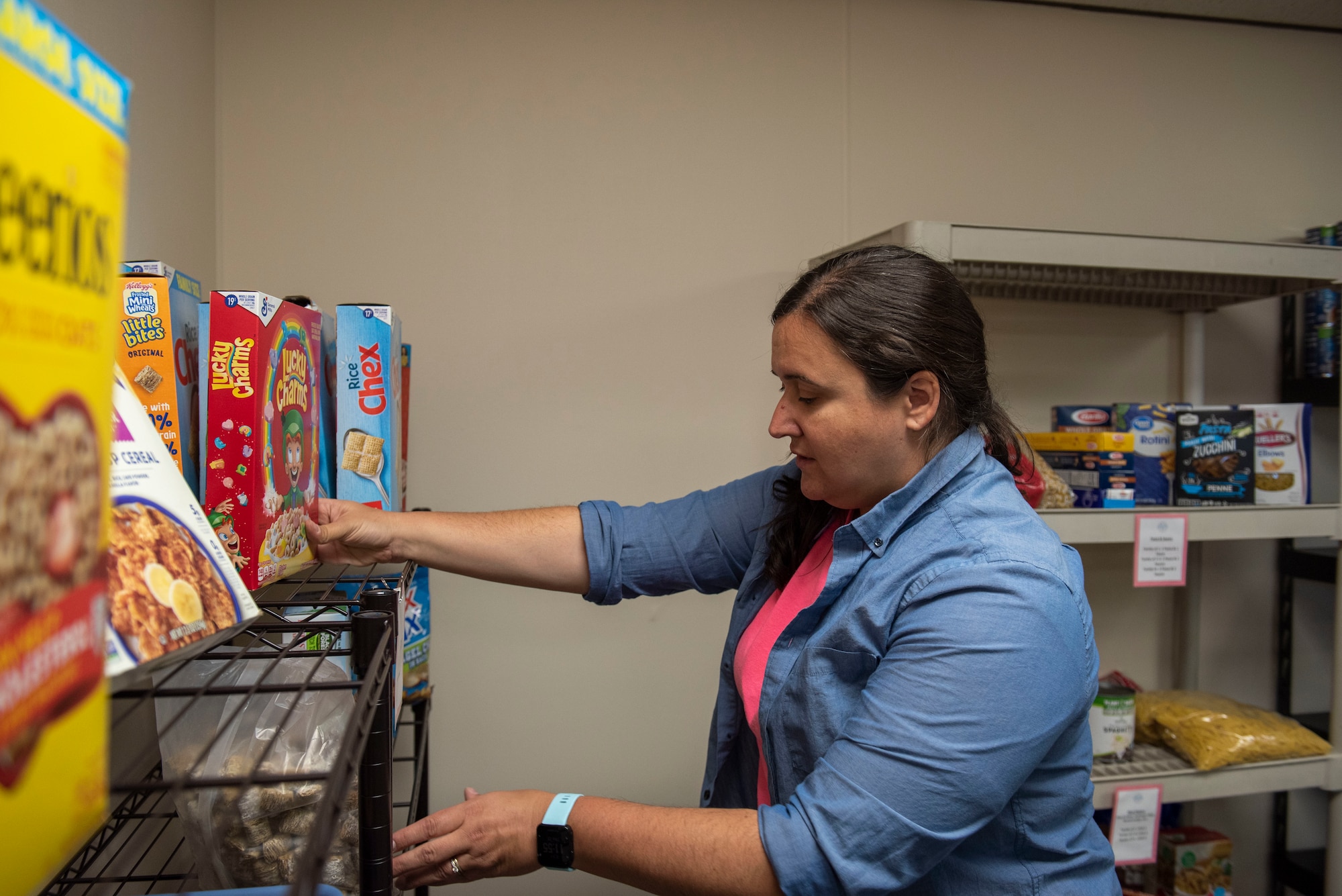 Sara Jemo, lead Food Pantry volunteer  and military spouse, stocks the shelves with cereal at the Fairchild Food Pantry at Fairchild Air Force Base, Washington, May 25th, 2023. Jemo is one of many volunteers that spend their spare time supporting Team Fairchild service members and families by providing a wide variety of free necessities. (U.S. Air Force photo by Airman 1st Class Lillian Patterson)