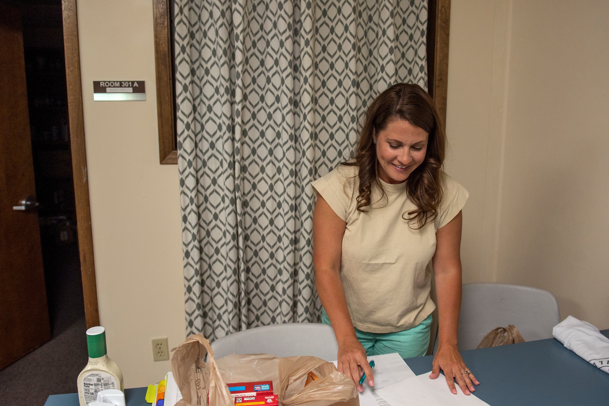 Brenna Marshall, Food Pantry Volunteer  and military spouse, organizes sign-up sheets at the Fairchild Food Pantry at Fairchild Air Force Base, Washington, May 25th, 2023. Marshall is one of many volunteers that spend their spare time supporting Team Fairchild service members and families by providing a wide variety of free necessities. (U.S. Air Force photo by Airman 1st Class Lillian Patterson)