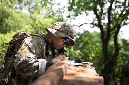 An Airman plots a route on a map propped against a ledge