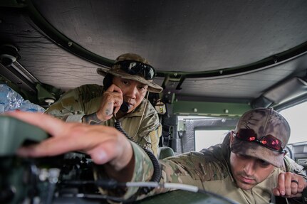 Airmen speak into a radio