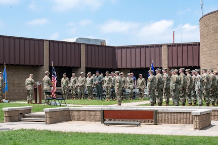 Airmen stand in formation outside for a squadron redesignation ceremony
