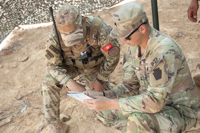 A guardsmen talks to a servicemember.