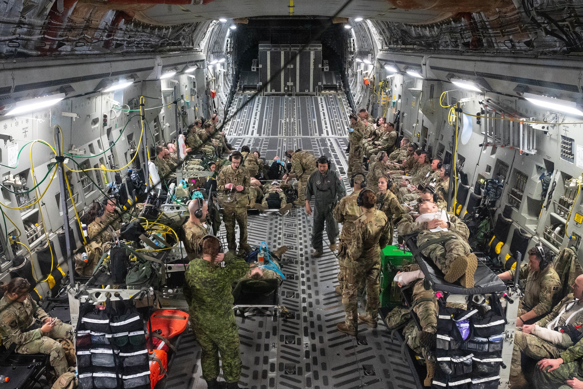 Airmen from the 934th Aeromedical Evacuation Squadron, 934th Security Forces Squadron, 934th Aeromedical Staging Squadron, 934th Civil Engineering Squadron, 452nd Aeromedical Evacuation Squadron, 452nd Aircraft Maintenance Squadron and the Royal Canadian Air Force work together to conduct a training exercise at the Minneapolis-St. Paul Air Reserve Station, May 5, 2023. The majority of the exercise took place aboard a C-17 Globemaster III aircraft but involved multiple patient transfers from UH-60 Blackhawk helicopters. (U.S. Air Force photo by Senior Airman Victoriya Tarakanova)